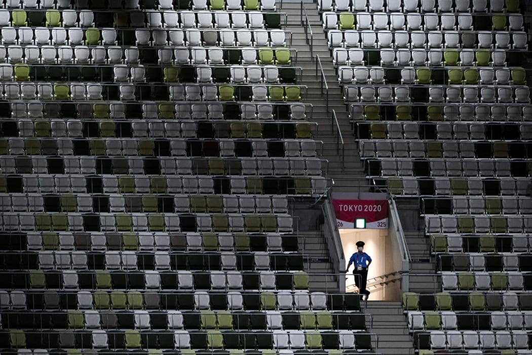 A police officer is seen in the empty stands ahead of the opening ceremony of the Tokyo 2020 Olympic Games.