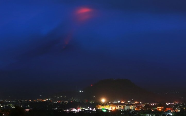 The glow of lava from the cloud-covered Mayon volcano as it erupts pictured from the Philippine city of Legazpi in Albay province.