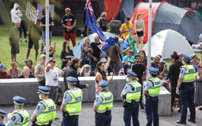 Police form a line around protesters at Parliament.