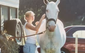 Sarah dresses a white horse