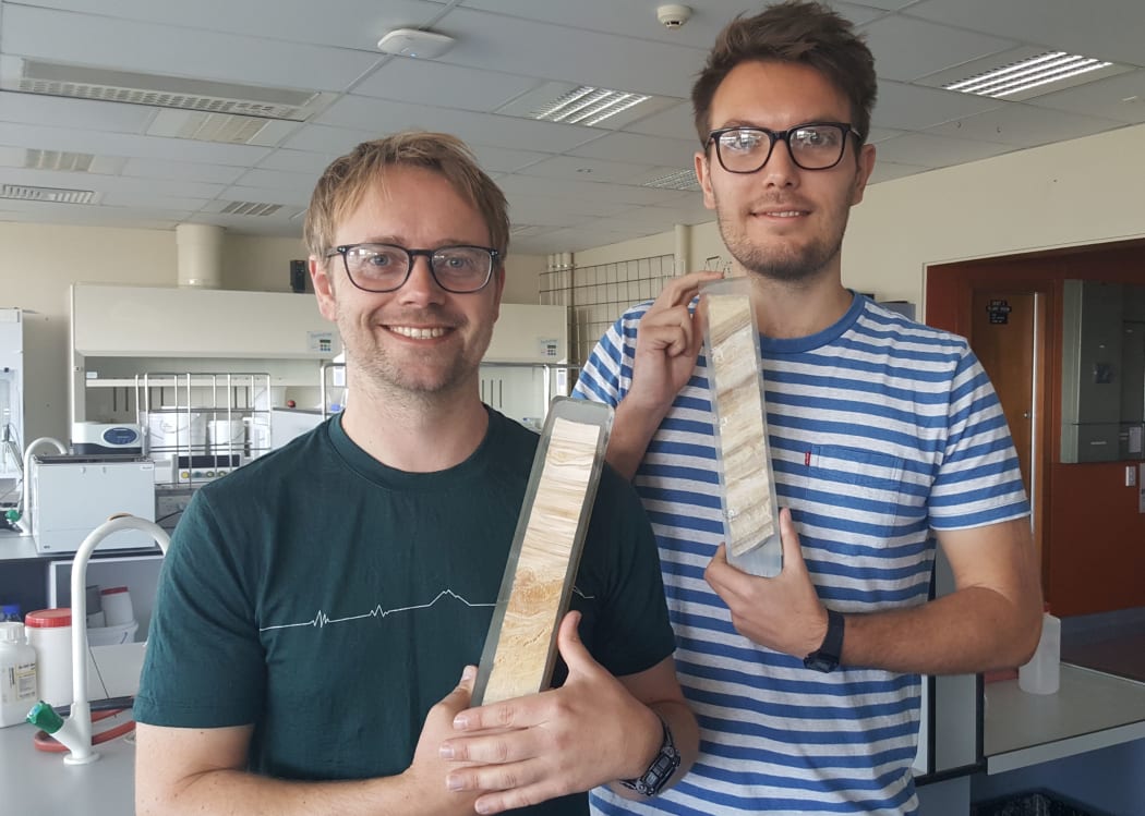 Adam Hartland and Andrew Pearson holding flowstones collected from a cave and encased in resin.