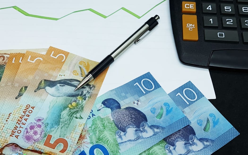 新西兰纸币、笔和计算器背景上趋势绿线上升