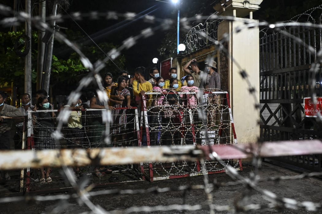 People wait outside the Insein Prison in Yangon on October 18, 2021, as authorities announced more than 5000 people jailed for protesting against a February coup which ousted the civilian government would be released.