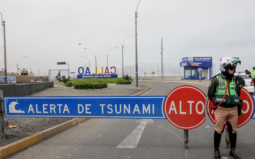A Peru's traffic police officer sets up a roadblock during a tsunami warning in La Punta, Callao province, Peru on July 30, 2025. Peru closed 65 of its 121 Pacific ports as a tsunami alert was issued on July 30, 2025, following a massive 8.8-magnitude earthquake off the east coast of Russia. (Photo by Connie FRANCE / AFP)