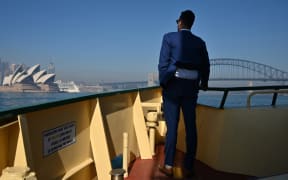 A commuter on a ferry watches as smoke from bushfires blankets Sydney on November 19, 2019. - Sydney woke up to a thick blanket of smoke as New South Wales warns residents of the dangers amid severe fire dangers and hot, windy weather. (Photo by PETER PARKS / AFP)