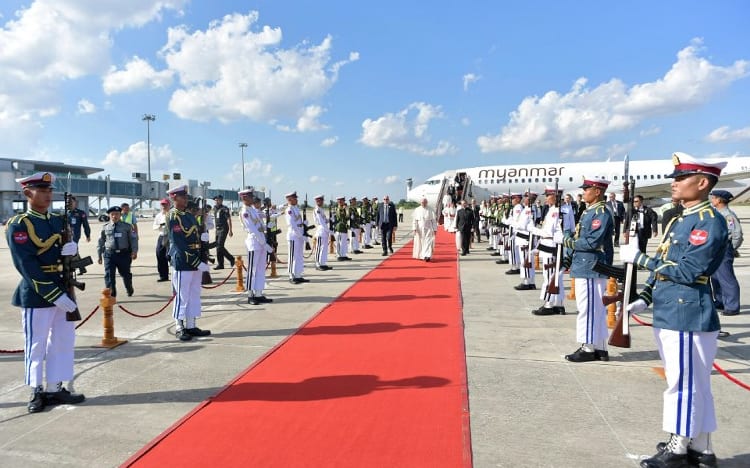 Pope Francis (C) walking past an honour guard as he arrives in Myanmar.