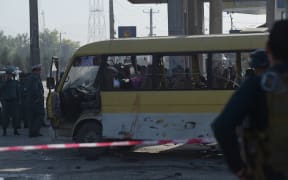 Afghan policemen look at the site of a suicide attack to have hit a minibus carrying foreign security guards in Kabul.