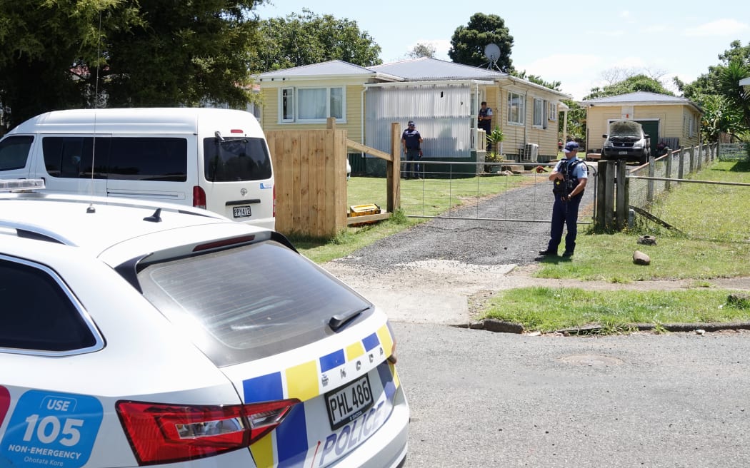 An armed officer stands guard at a Kaikohe home where a man was shot this afternoon.