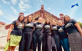 from Left-Right is in front of the Wharenui at Rāwhitiroa marae. Names (Left to right) are Ngahuia Kopa, Kyea Watene-Hakaria, Lisa Begbie, Tyra Begbie, K-lee Begbie, Arahia Moeke, Naomi Simmonds.