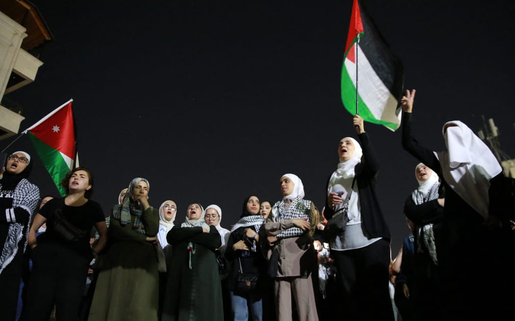 Women wave flags as they protest near the Israeli embassy in Amman, to denounce the assassination of Palestinian Hamas chief Ismail Haniyeh, on August 1, 2024. Hamas said on July 31 its political leader Ismail Haniyeh was killed in an Israeli strike in Iran, where he was attending the swearing-in of the new president, and vowed the act 