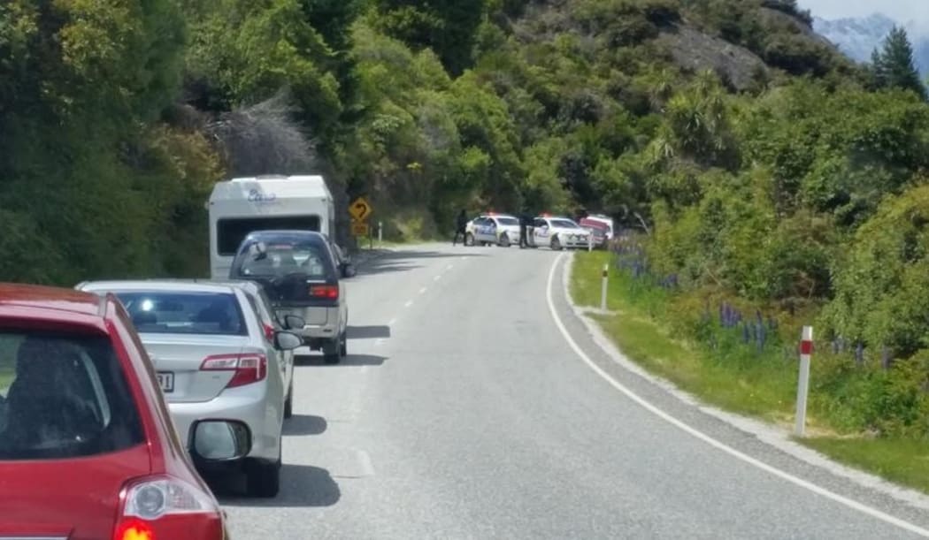 Traffic backs up while the Armed Offenders Squad arrests two people.