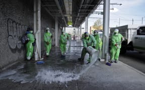 Municipal workers clean and disinfect a sidewalk in Tepito neighborhood in Mexico City