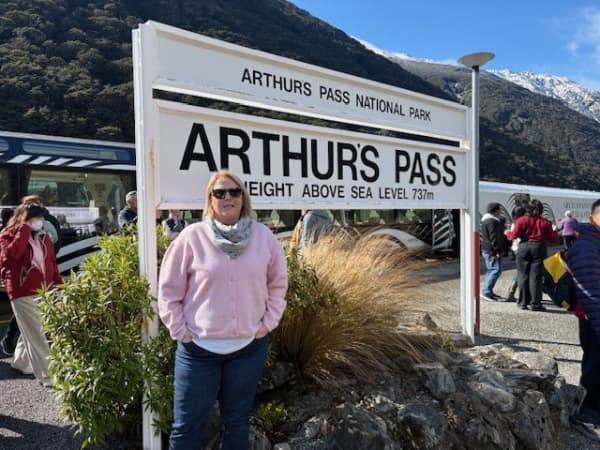 Kath Cross stands at Arthur's Pass sign on her first birthday after her lungs transplant surgery.