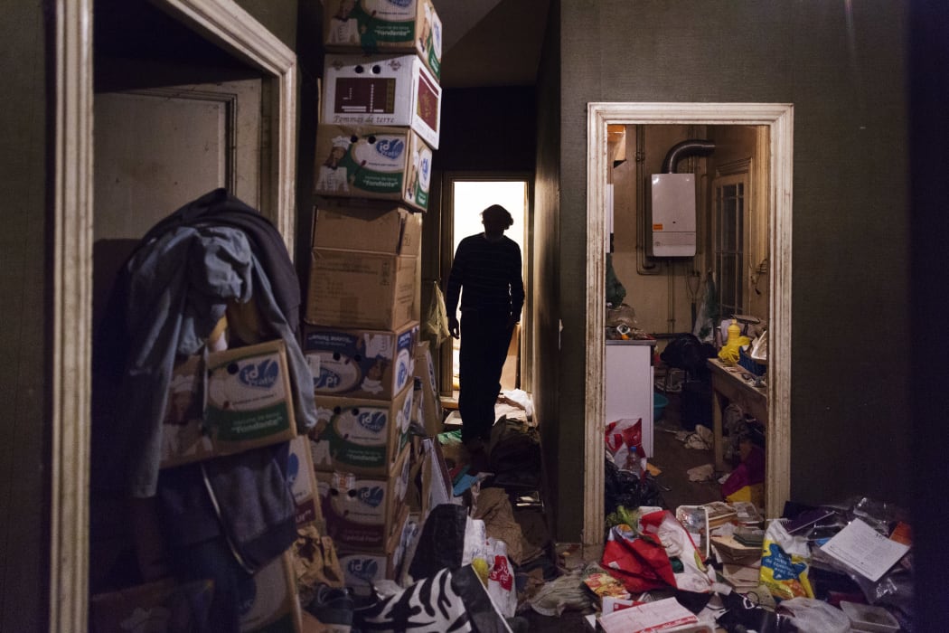 A man with diogenes syndrome or compulsive hoarding lives alone in his garbage-filled apartment in the city.