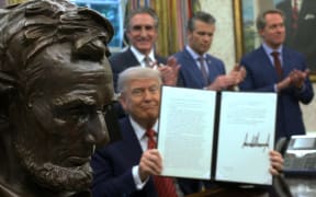 WASHINGTON, DC - MAY 23: U.S. President Donald Trump holds up a signed executive order next to a bust of former U.S. President Abraham Lincoln in the Oval Office of the White House May 23, 2025 in Washington, DC. President Trump signed executive orders related to the nuclear power industry.   Win McNamee/Getty Images/AFP (Photo by WIN MCNAMEE / GETTY IMAGES NORTH AMERICA / Getty Images via AFP)