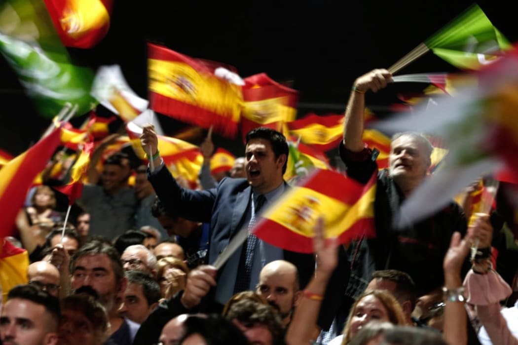 Supporters wave Spanish flags during a rally of Spanish far-right Vox part.