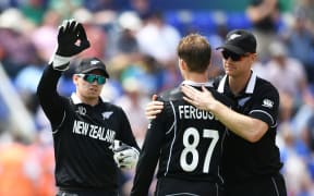 Lockie Ferguson is congratulated by Tom Latham and Jimmy Neesham after taking the wicket.