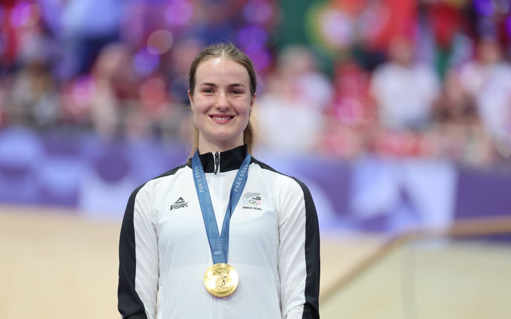 Picture by Alex Whitehead/SWpix.com - 11/08/2024 -  Paris 2024 Olympic Games - Track Cycling - National Velodrome, Saint-Quentin-en-Yvelines, France - Women's Sprint - Ellesse Andrews (New Zealand) on the podium receiving the Olympic Gold Medal after winning the Women's Sprint to become Olympic Champion