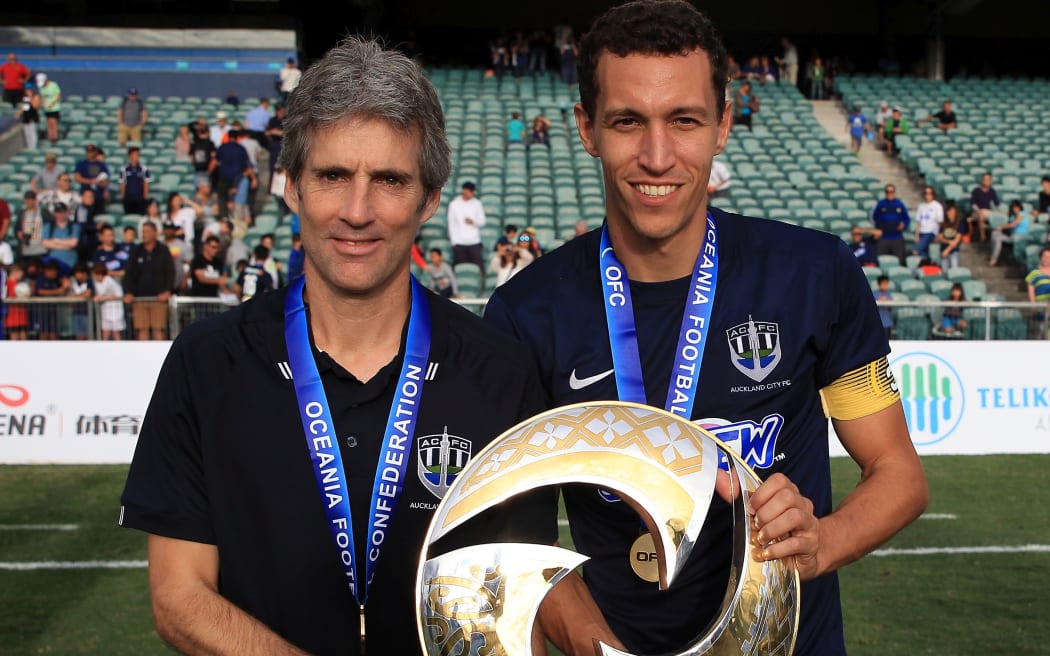 Auckland City coach Ramon Tribulietx and captain Angel Luis Viña Berlanga pose with the OFC trophy.