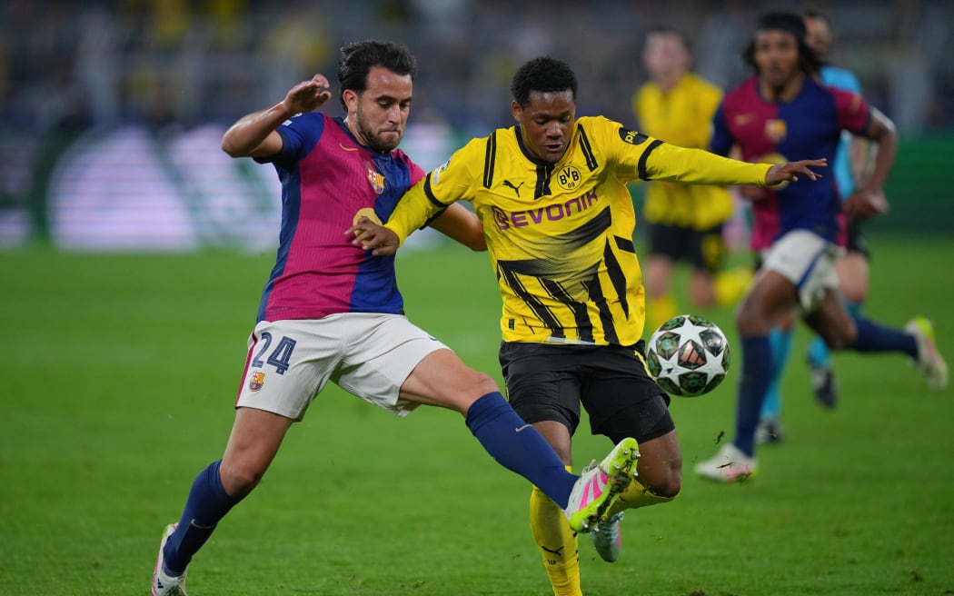 Barcelona's Spanish defender (L) tackles Borussia Dortmund forward Julien Duranville.