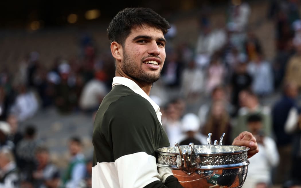 Spain's Carlos Alcaraz holds the trophy after winning the men's singles final match against Italy's Jannik Sinner on day 15 of the French Open tennis tournament on Court Philippe-Chatrier at the Roland-Garros Complex in Paris on June 8, 2025. (Photo by Thibaud MORITZ / AFP)