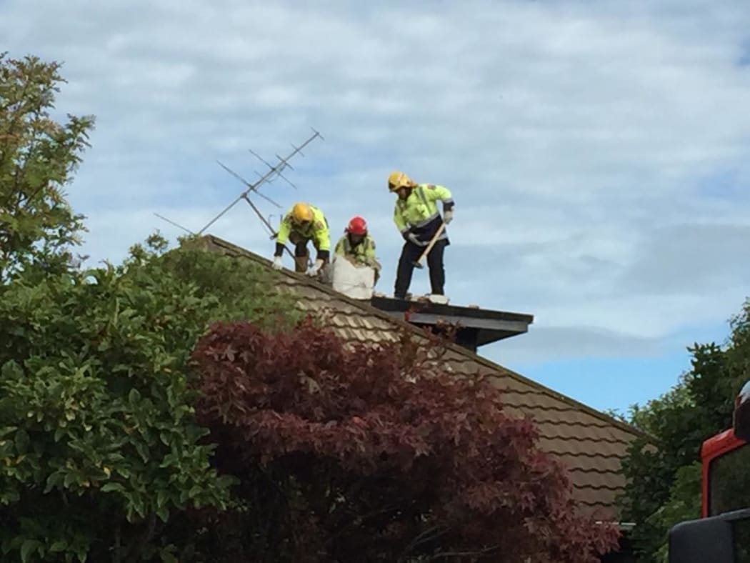 Firefighters are smash down a chimney after reports a man is trapped.