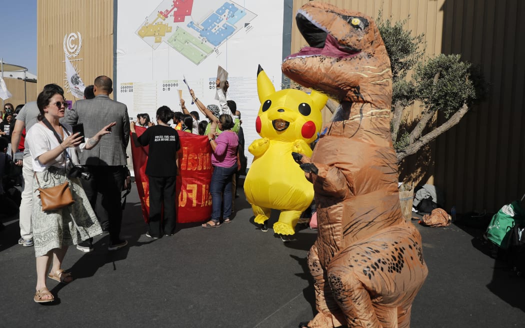 Demonstrators using animated figures shout slogans during a protest outside the venue hosting the COP27 climate conference.