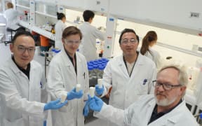 Ruminant Bio Tech's R&D team holding boluses, designed to curb methane emissions in cattle, in front of the lab team producing a batch of boluses