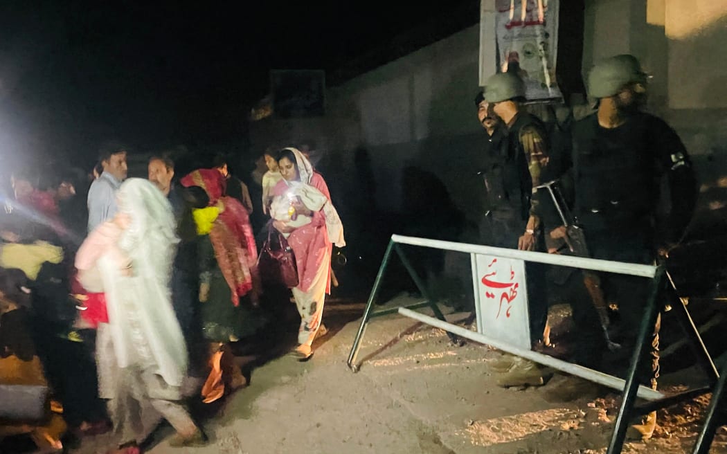 Security personnel cordon-off a street as local residents evacuate their homes near the site of a strike in Muzaffarabad, the capital of Pakistan-administered Kashmir, on 7 May, 2025.