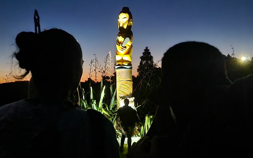 A pou representing the hapū Te Kapotai is unveiled as dawn breaks.