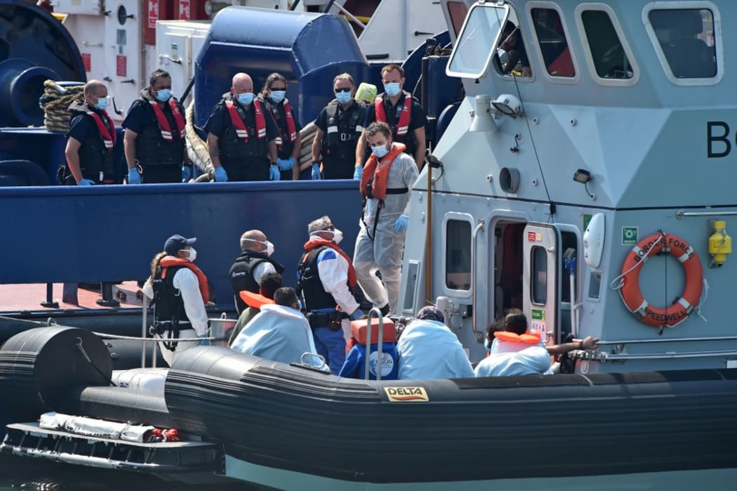 UK Border Force officers come to meet migrants, believed to have been picked up from boats in the Channel, from Coastal patrol vessel "HMC Speedwell", in the port of Dove.