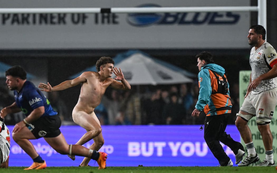 A streaker invades the pitch.