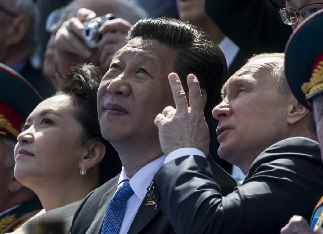 Russian President Vladimir Putin (R) speaks with Chinese President Xi Jinping (C).