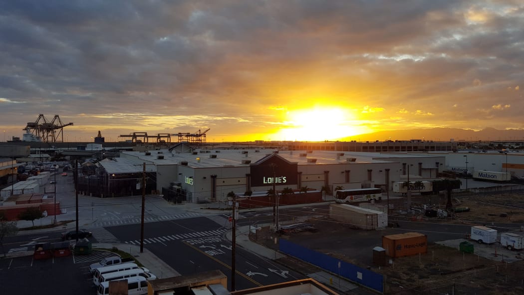 HONOLULU - 2016 APRIL 10: Sunset over Lowe's and Shipping Cranes with Matson Shipping containers around building on Oahu, Hawaii.