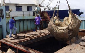 Bags of copra - dried coconut meat - are lifted from the hold of a government field trip vessel for delivery to the Tobolar Copra Processing Authority plant in Majuro.