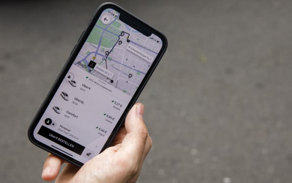 PRODUCTION - 01 September 2021, Berlin: The mobile app for ordering an Uber car is seen on a smartphone. Photo: Carsten Koall/dpa (Photo by CARSTEN KOALL / DPA / dpa Picture-Alliance via AFP)