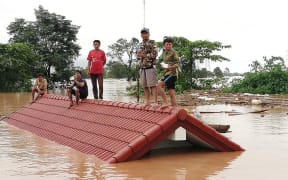 Residents on rooftops surrounded by floodwaters in Attapeu province in southern Laos after a dam collapsed on July 23.