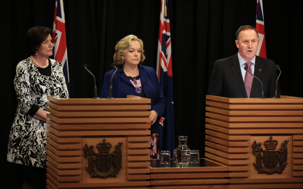 Hon Anne Tolley, Judith Collins and PM John Key presenting a package to prevent family violence.