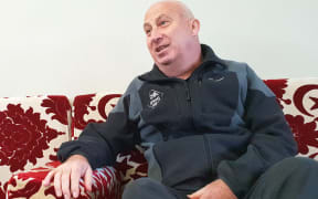Man sitting on couch with a big red pattern