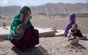 — Two of the mothers of the seven children who died in the blast on April, 2014, Baskul and Tohira, with one of Tohira’s other children, at the cemetery where the children are buried.