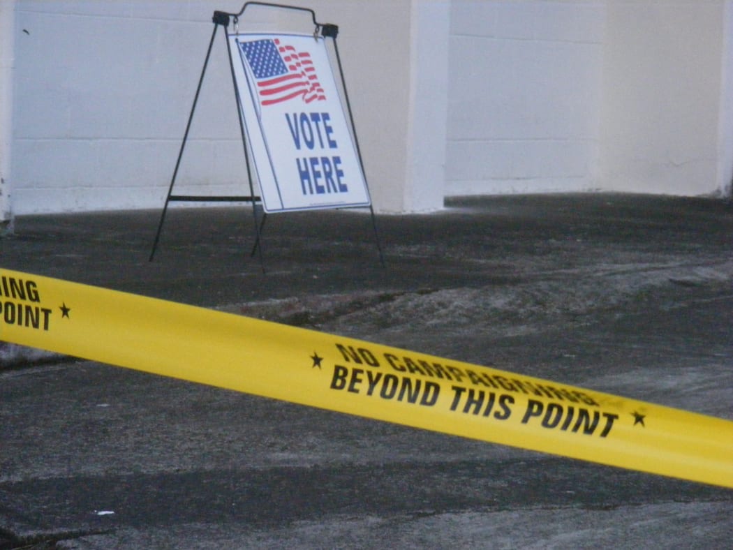 A “Vote Here” sign, with yellow tape “no campaign beyond this point” is a common scene for voters entering one of the 44-polling stations in American Samoa.