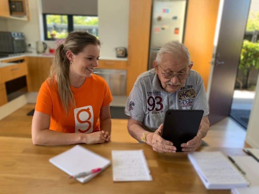 UC student Phoebe McCaughan providing one-on-one tech tutoring to a client