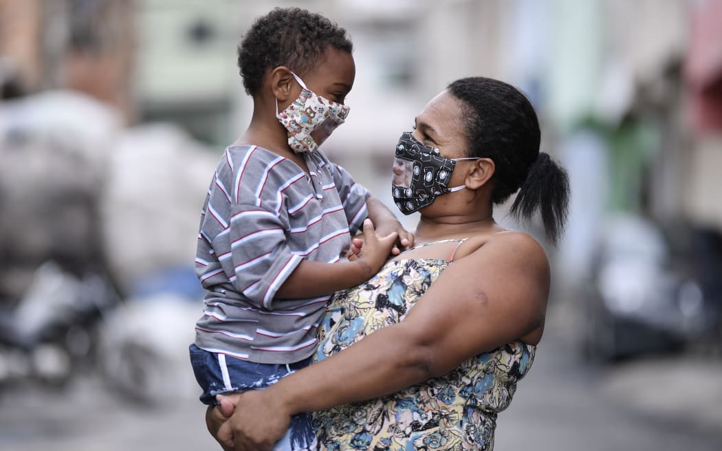 Brazilian Juliene Maria Conceicao, who is hearing impaired, holds her son, Leonardo Moreira Conceicao, both wearing protective masks against the spread of the new coronavirus (COVID-19)  in Belo Horizonte, Brazil on May 15, 2020. -