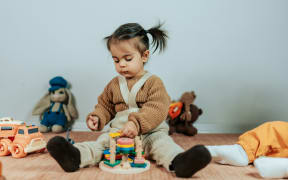 A little kid playing with toys.