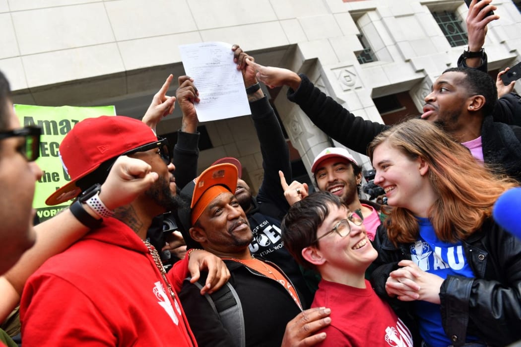 Union organizer Christian Smalls celebrates with Amazon workers following their win.