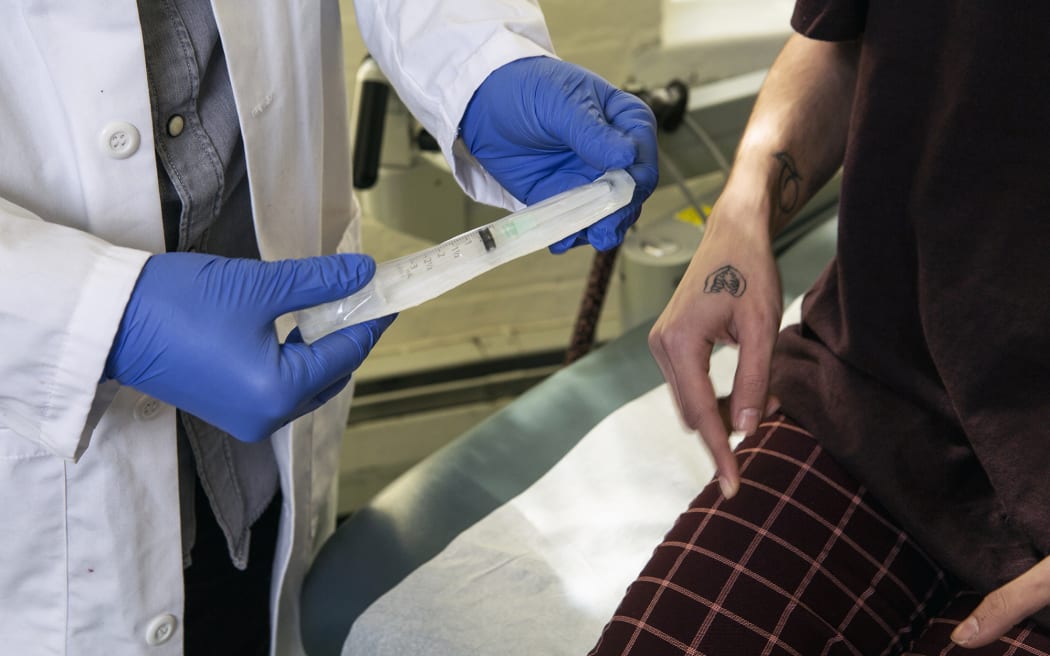 A doctor showing a patient a syringe used to inject testosterone.
Guidelines for use: https://genderspectrum.vice.com/guidelines