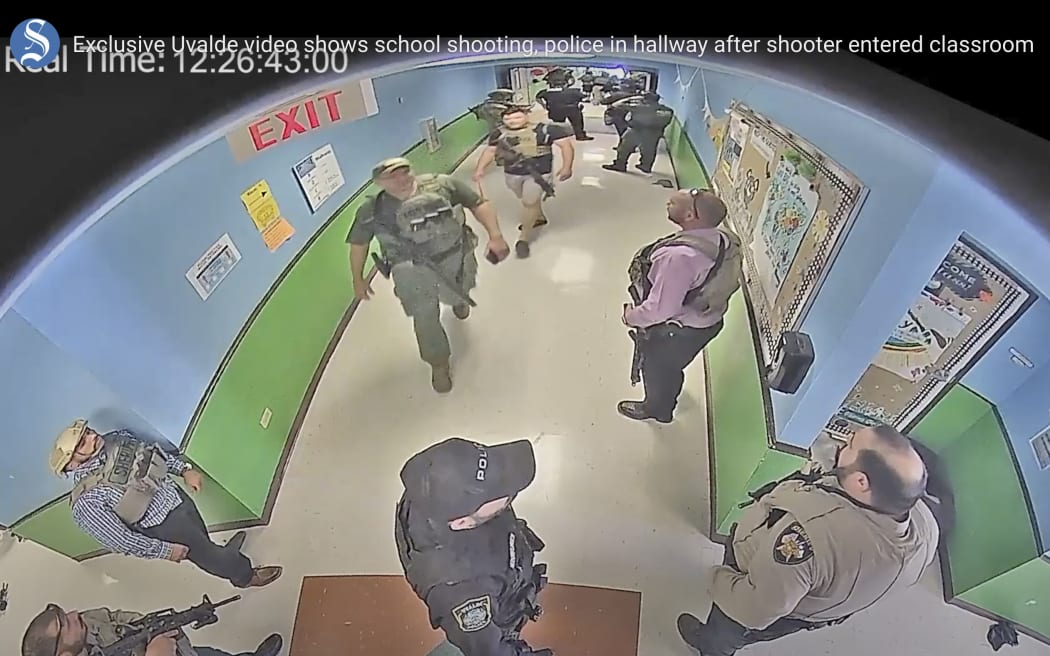 An image from surveillance video shows authorities staging in a hallway as they respond to the shooting at Robb Elementary School in Uvalde, Texas, on 24 May, 2022.