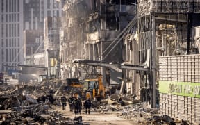 Ukrainian firefighters and servicemen work next to a digger amid the rubble of the Retroville shopping mall, a day after it was shelled by Russian forces, Kyiv, 21 March 2022.