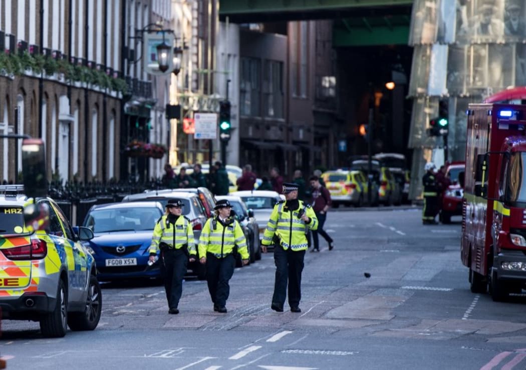 Police officers and emergency response vehicles are seen on the street outside Borough Market.