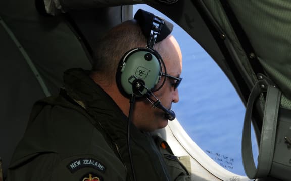 A crew member from the Royal New Zealand Air Force looks for objects in the Indian Ocean.
